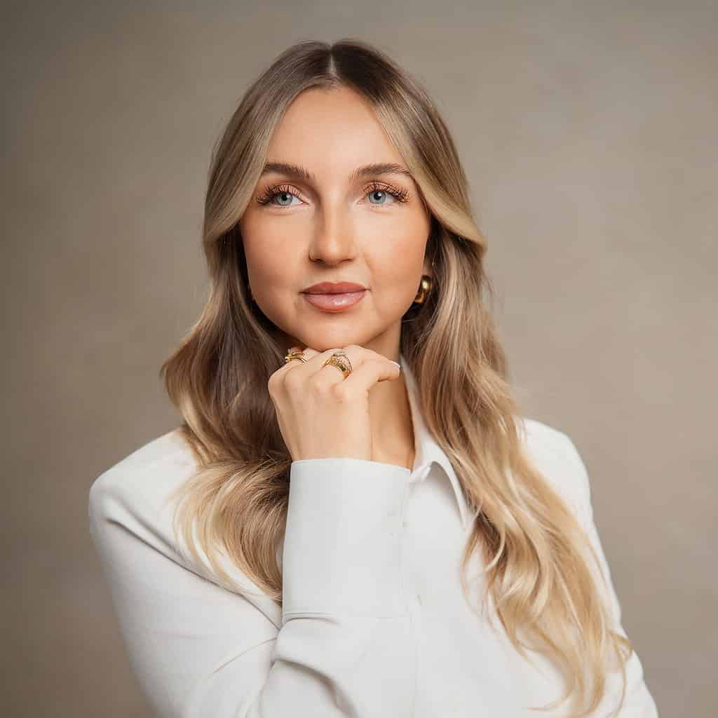 Stilvolle Frau mit langem, gewellten Haar und eleganter Whiteout-Montur, Porträt, modische Frisur, professioneller Look.