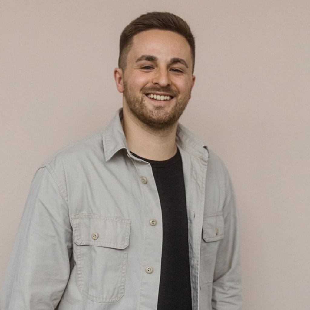 Porträt eines jungen mannes vor neutralem hintergrund für fotografie und medien, professionell, freundlich, lächelnd.